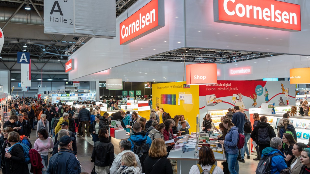 Eine volle Halle mit Besucher:innen auf der Leipziger Buchmesse 2024 und dem großen Cornelsen Messestand im Vordergrund