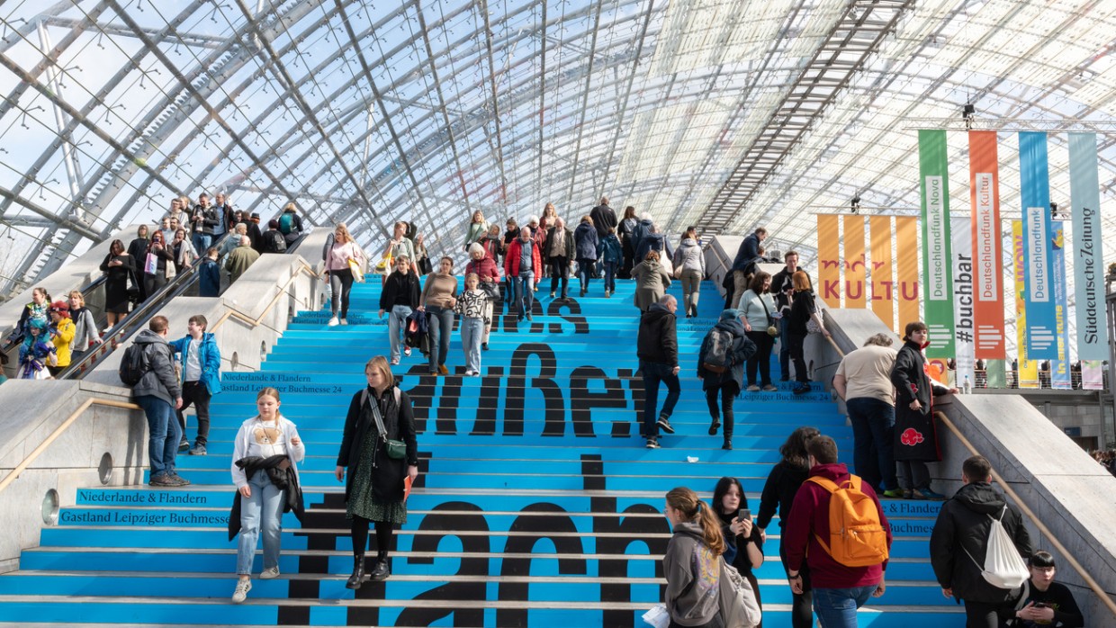 Blau bedruckte Treppe in der Glashalle Fokus auf den Gastland-Slogan "alles außer flach" während der Leipziger Buchmesse 2024
