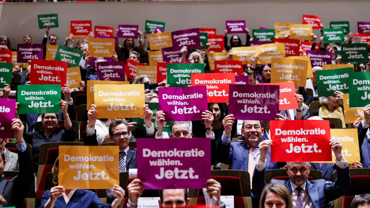 Publikum bei der Eröffnungsfeier der Leipziger Buchmesse 2024 im Gewandhaus zu Leipzig, das Schilder mit der Botschaft „Demokratie wählen. Jetzt.“ hochhält