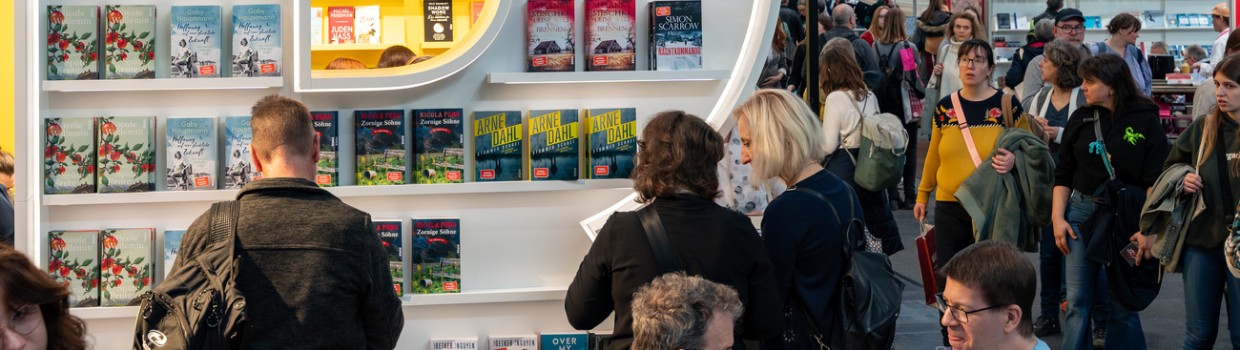 Impression von der Ausstellungsfläche der Leipziger Buchmesse 2024 mit Messeständen und Besucher:innen